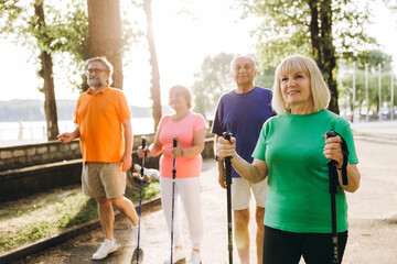 Obraz premium Seniors enjoying nordic walking outdoors for health and fitness