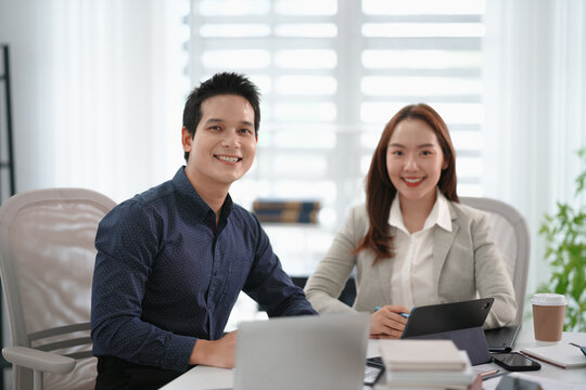 Asian mentor and supervisor working together to support training of office trainee in business strategy