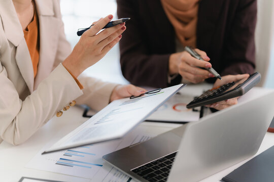 Corporate analyst sitting at desk with audit papers, financial ledger and calculator in business environment