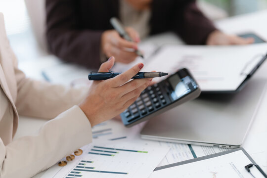 Corporate analyst sitting at desk with audit papers, financial ledger and calculator in business environment