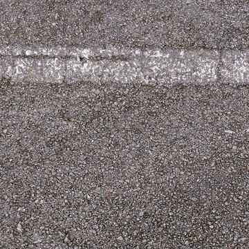 High-angle, close-up shot of a wet asphalt road surface featuring a weathered and faded white paint line running horizontally. The dark, rough gravel texture is damp.