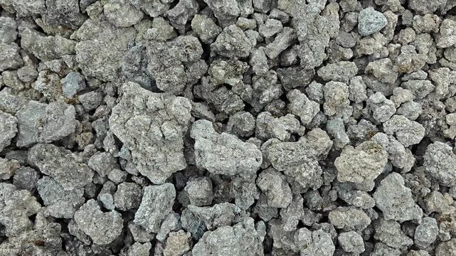 Top down full frame view of rough volcanic rock stones and gray pebbles texture