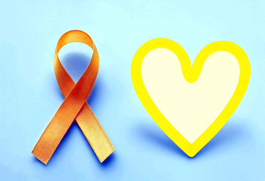 Bright orange awareness ribbon and yellow outlined heart shape on blue background symbolizing support and love