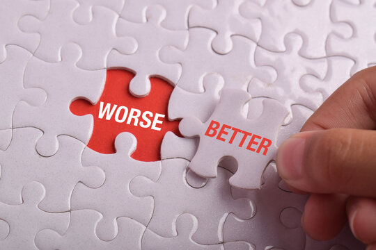 Hand replacing a worse jigsaw piece with better on a white puzzle, symbolizing improvement, positive change, better decisions, problem solving, growth, and continuous progress.