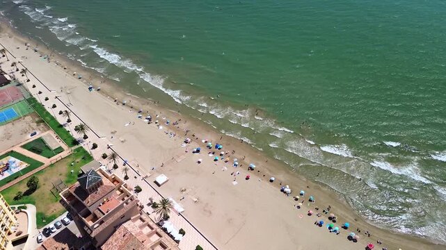 High angle look at colorful sun parasols on a crowded shore during summer