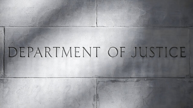Stone wall engraved with the words department of justice in capital letters