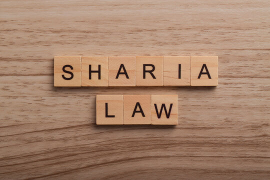 Wooden letter blocks spelling Sharia Law on a wooden background, representing Islamic legal principles, justice, religion, legislation, governance, and legal concepts.