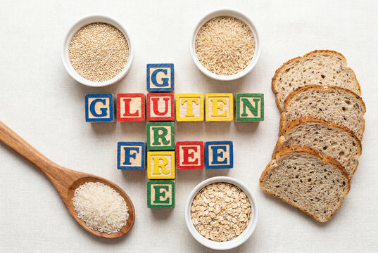 Gluten free ingredients and spelled out wooden blocks arranged on a textured white cloth