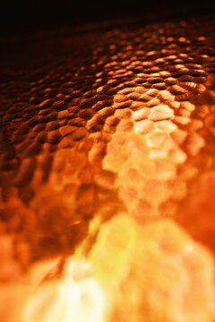 Close-up of crackling campfire flames at night. Burning embers and glowing firewood in low light outdoor setting.
