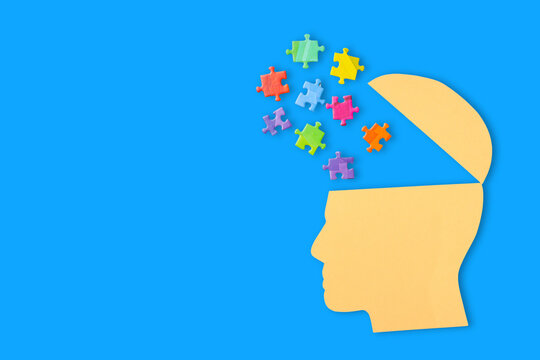 Colorful puzzle pieces float above a head, symbolizing creativity