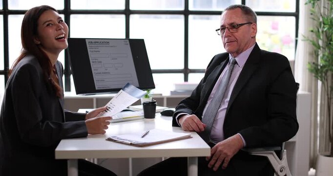Young businesswoman attending a job interview, holding a document while a male recruiter reviews applicants on a clipboard, signifying human resources, career planning, and new employment