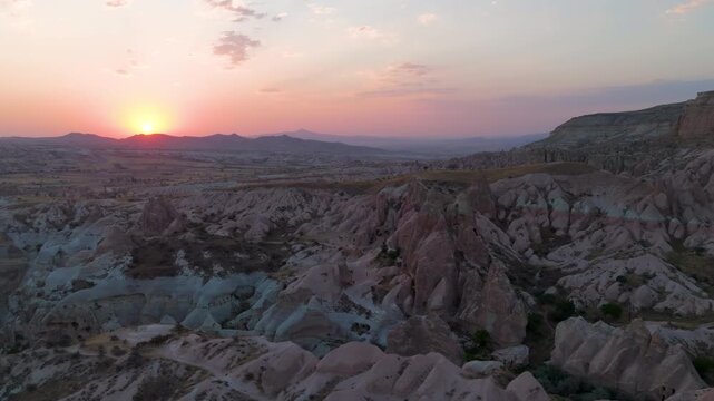 Goreme, Nevsehir, Turkey. Red Valley sunset, eroded volcanic tuff formations glowing in warm golden light, aerial panoramic view over the vast Cappadocian landscape. Aerial View