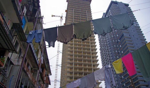 Urban contrast in Batumi with colorful laundry drying against building construction