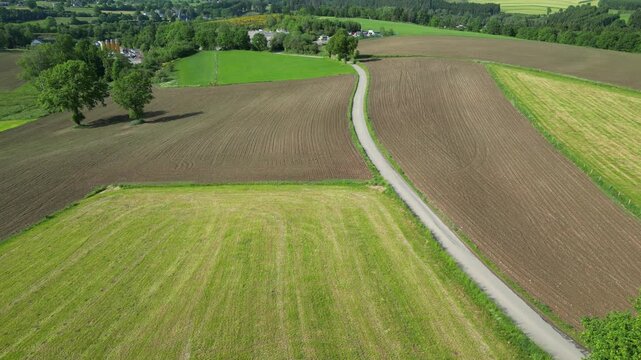 Cinematic Fly-Over of a Scenic Rural Landscape with Patchwork Farmland and a Country Road