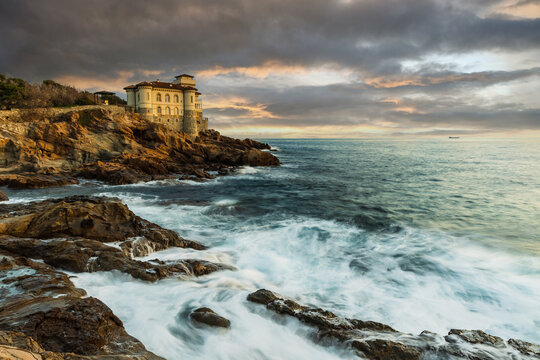 Boccale castle landmark on cliff rock and sea on sunset. Tuscany, Italy