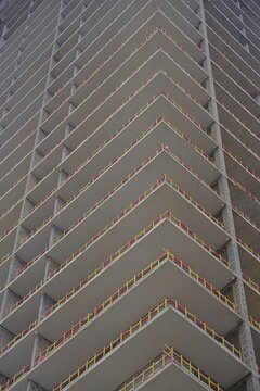 Modern concrete skyscraper under construction with yellow safety barriers and copy space