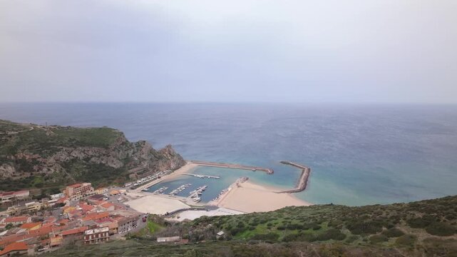 Coastal Harbor And Waterfront Of The Historic Seaside Town Of Buggerru In Sardinia, Italy. Aerial Shot