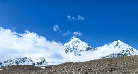 Snow-capped peaks of the Himalayas in Tibet under a clear blue sky with drifting clouds © wendi
