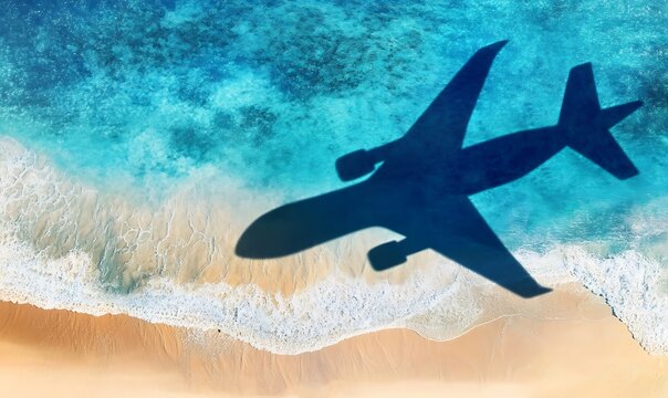 Airplane shadow flies over tropical beach with blue ocean waves and golden sand.