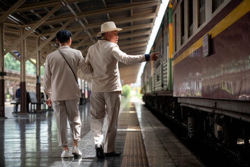 Fototapeta premium Happy senior LGBTQ couple met at Bangkok's old train station in Thailand