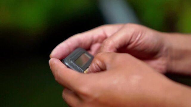 Hand holding pager beeper device, retro phone 90s instant communication and connection, sms messaging in the early 80s 90s digital age