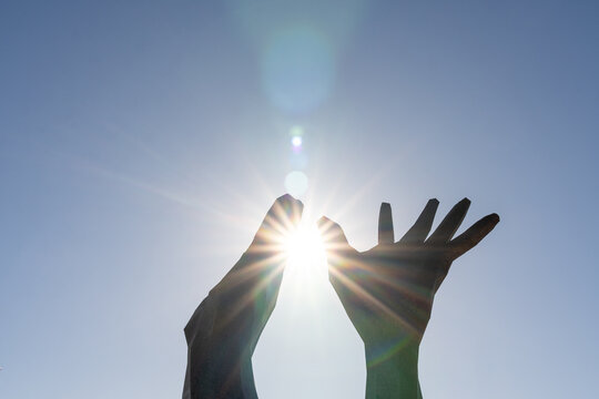 Mediterranean. Hands raised to the sky towards the sun