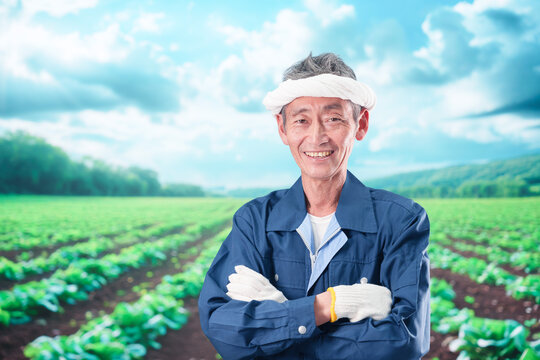 笑顔で腕を組む農家の男性
