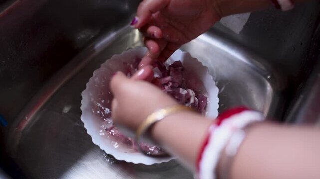 An Indian married woman hygienically washing fresh raw mutton in a kitchen basin before cooking. Close-up of clean red meat preparation, traditional home cooking, food safety, healthy meal preparation