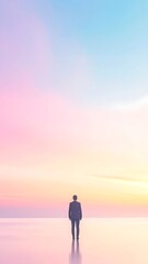 Fototapeta premium Man standing alone on beach sunset.