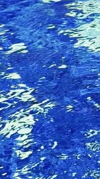 Shimmering blue water ripples form flowing abstract reflections in bright sunlight.