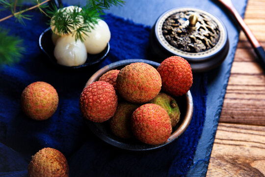 Whole And Peeled Fresh Lychee Fruits On Dark Wooden Tray