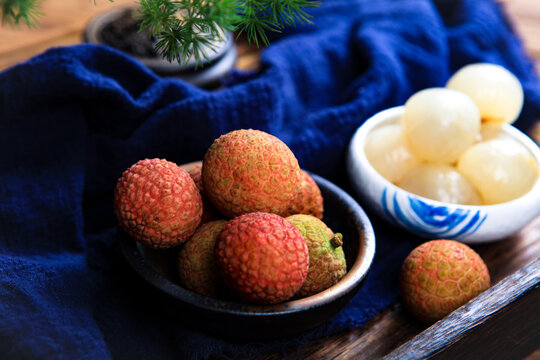 Whole And Peeled Fresh Lychee Fruits On Dark Wooden Tray