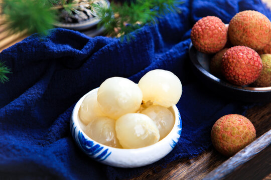 Whole And Peeled Fresh Lychee Fruits On Dark Wooden Tray