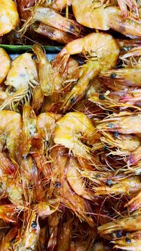 Fresh orange prawns form a colorful seafood display at a traditional local market.