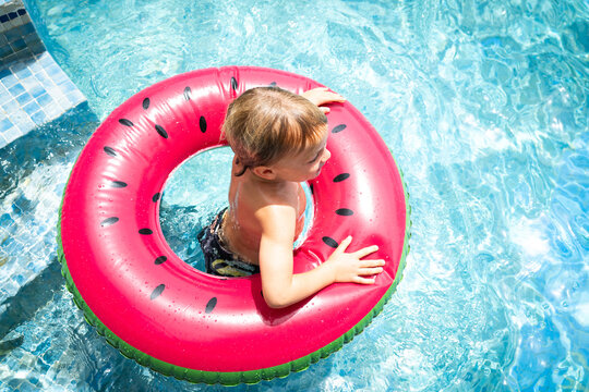Young kid in pool with watermelon ring floatie