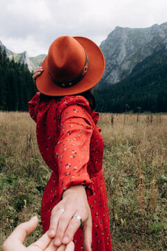 Woman leading partner through mountains