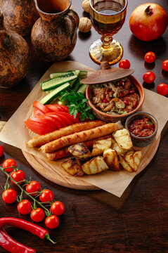 Georgian feast with sausages potatoes and fresh vegetables