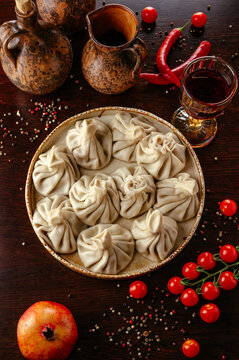 Georgian khinkali dumplings with wine on a rustic table