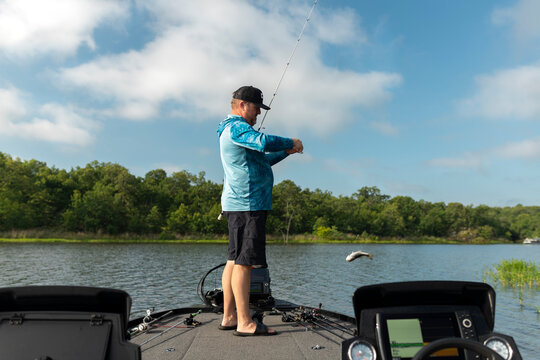 Man on a bass boat releases caught fish