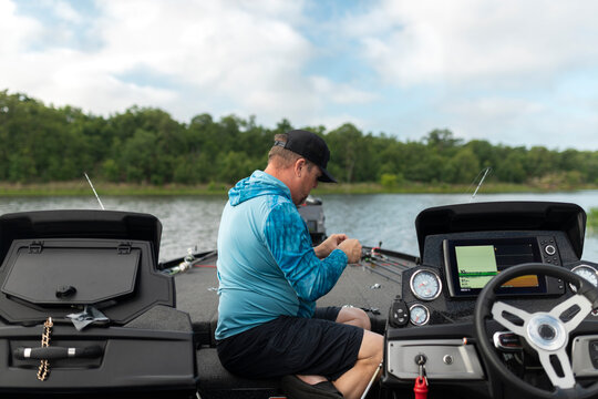 Man rigging his fishing line on a bass boat