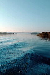 Obraz premium Calm water waves rise and fall near the coastline at dusk during a quiet evening in a coastal area