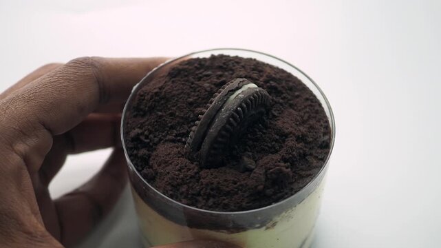 Close up on layered dessert with crushed cookies and oreo on top