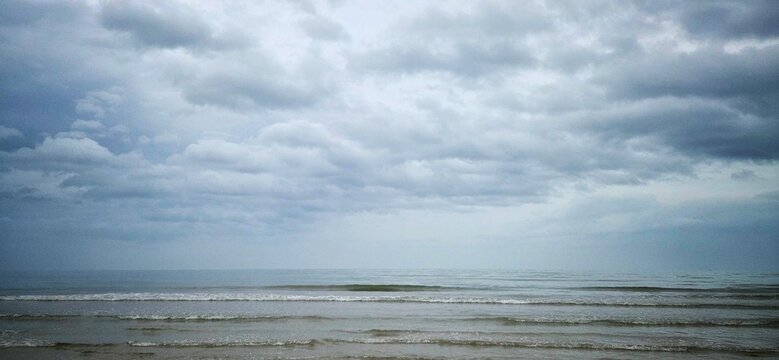 Gloomy Ocean Horizon in Rainy Season, Dark Overcast Sky Over Calm Sea, Moody Gray Sea Under Stormy Clouds, Mental Health Metaphor Background.