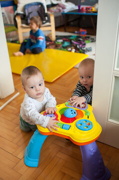 Toddlers explore a vibrant learning station at home, discovering and playing as their older brother watches nearby