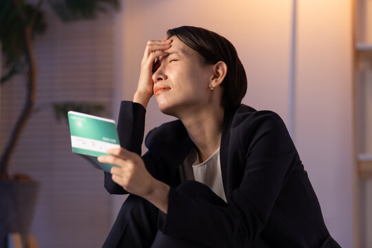 通帳を見る女性