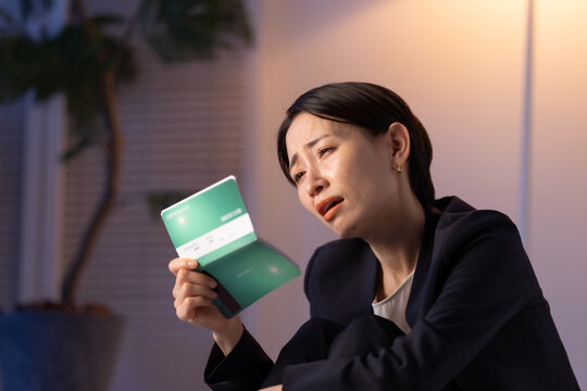 通帳を見る女性