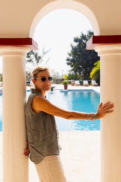 portrait of adult woman on vacation, pool in background