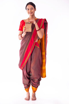 Portrait of a Maharashtrian woman putting coin into money box