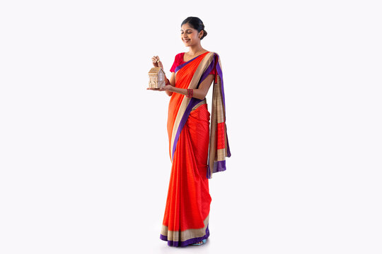 Portrait of a young woman putting coin into money box
