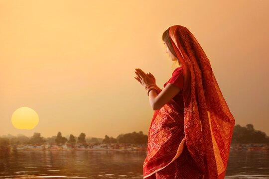 woman from Bihar offers prayers to the  sun  in the  early morning hours during  Chhath Puja festival